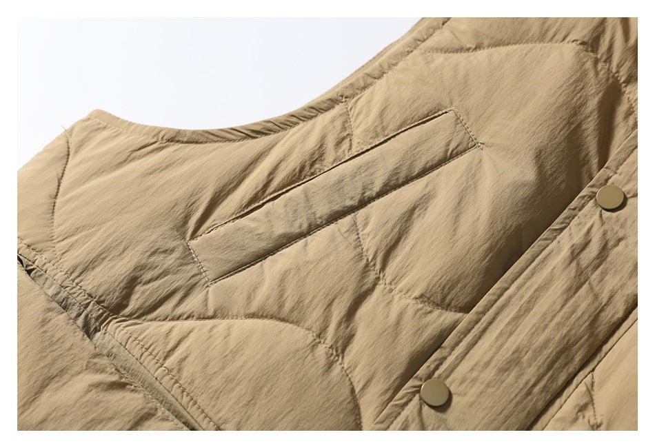Close-up of a horizontal welt pocket and quilted stitching on the tan vest front.