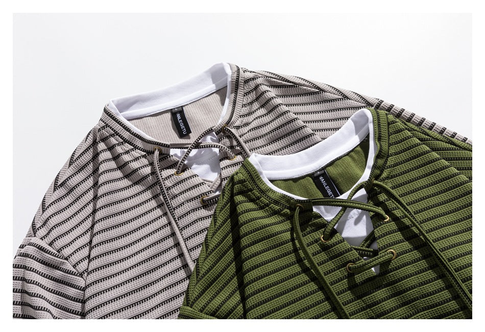 Close-up of two striped lace-up tops in light gray and olive green, showing their contrasting collars and necklines.