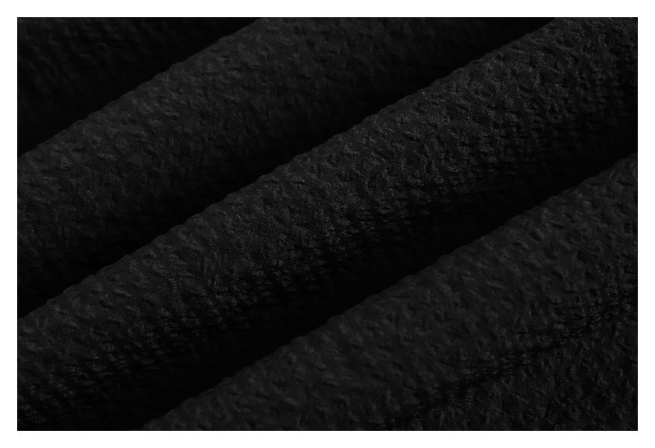 Extreme close-up of black fabric showing its raised, irregular texture.