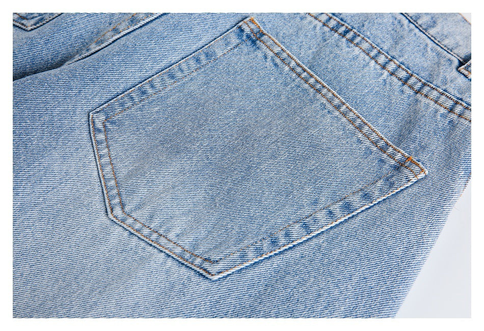 Close-up of a back pocket on light blue jeans with contrasting topstitching.