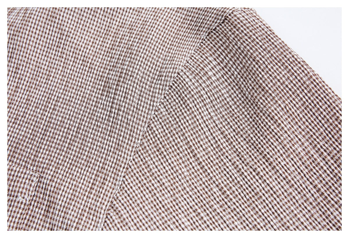 Close-up of brown-and-white checked shirt fabric with a diagonal seam and panel edge.