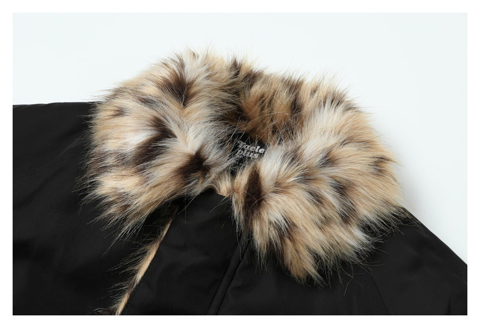 Close-up of a black coat with a plush tan, cream, and dark-brown fur-trimmed collar.