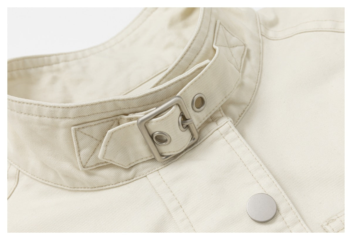 Close-up of the ivory jacket's collar strap, square metal buckle, eyelets, and snap button.
