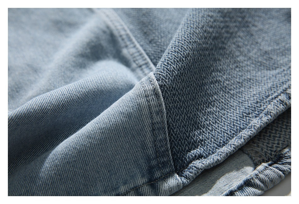 Close-up showing the seam between light blue denim and a darker patterned denim panel.