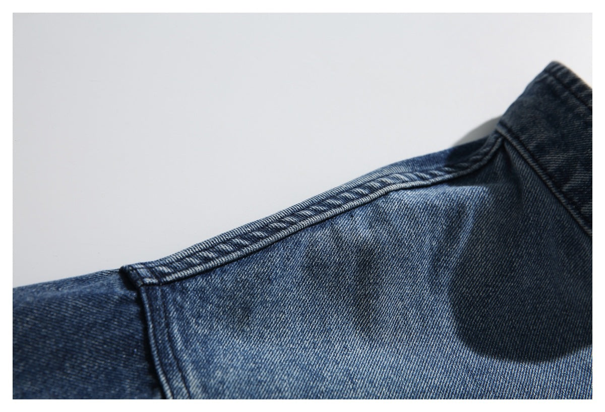 Close-up of the shoulder seam and yoke on a blue denim jacket.