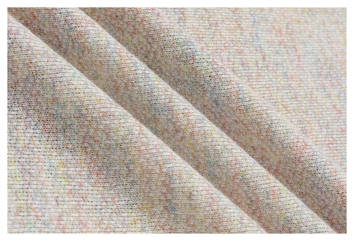 Macro view of the knit texture and fine multicolored flecks in pale fabric.
