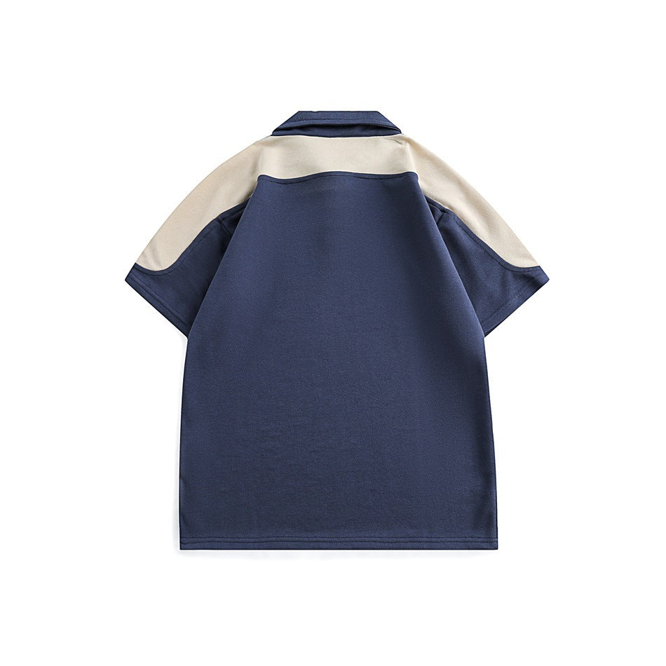 Back view of a navy short-sleeve polo shirt with cream shoulder panels and a navy collar.