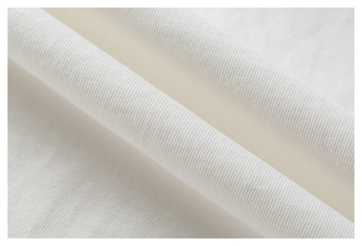 Close-up of white garment fabric folded to show its ribbed edge and knit texture.