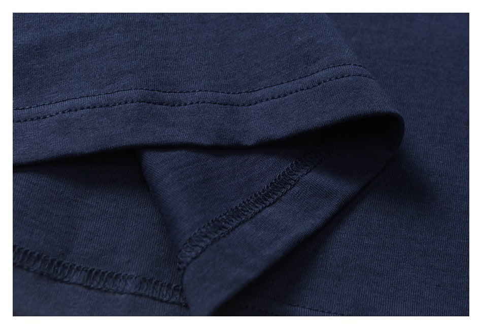 Close-up of a navy garment's folded hem and overlock stitching.