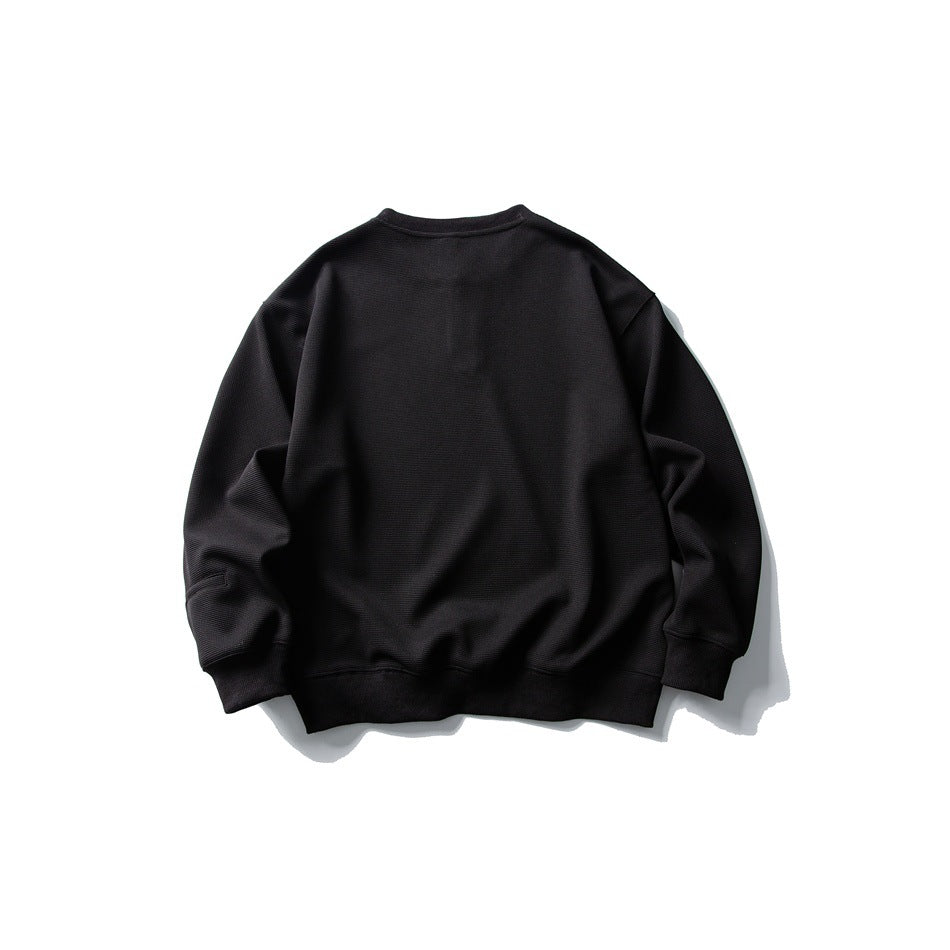 Back view of black textured crewneck sweatshirt with dropped shoulders and ribbed cuffs and hem, laid flat