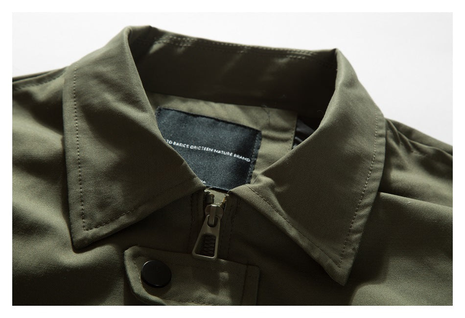 Close-up of an olive-green jacket collar, zipper, snap tab and sewn-in neck label.