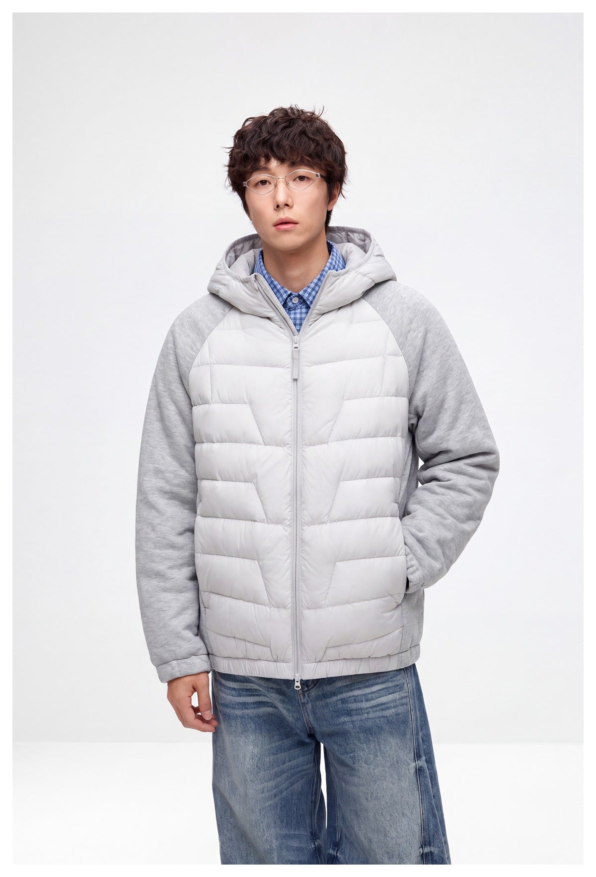 Model wearing a light gray hooded jacket with a quilted front and heather gray raglan sleeves.