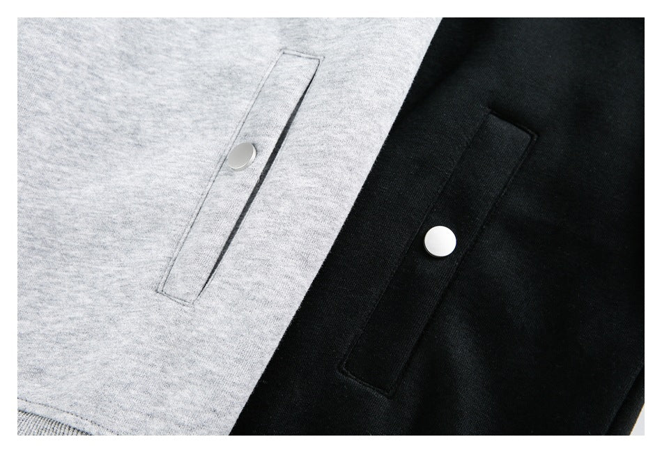 Close-up of gray and black hoodie pockets with round snap closures.