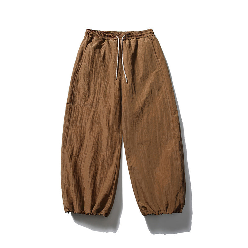 Caramel brown wide-leg drawstring pants with crinkled texture and gathered hems, flat front view