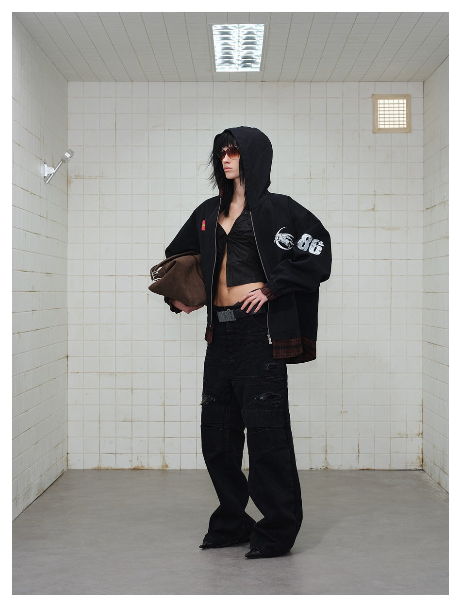 Three-quarter view of a model in a black hooded jacket with white sleeve graphics and burgundy plaid trim.