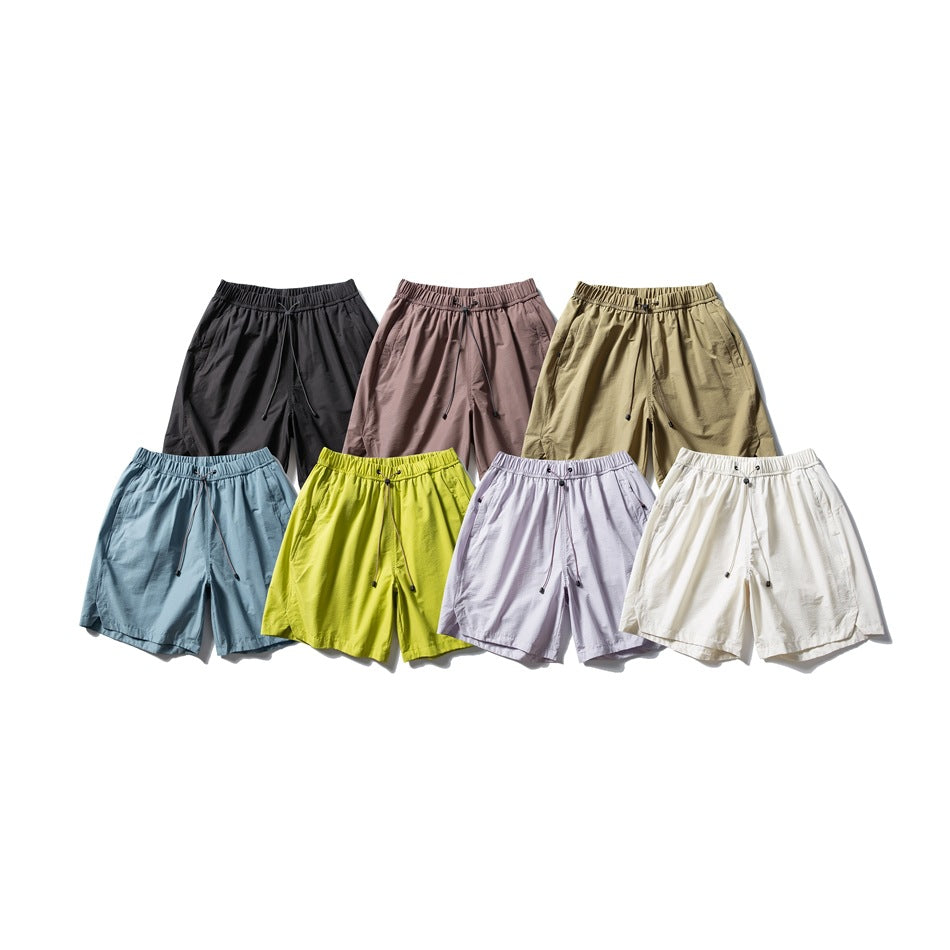 Seven pairs of drawstring shorts in black, mauve brown, khaki, dusty blue, lime green, lavender and cream white