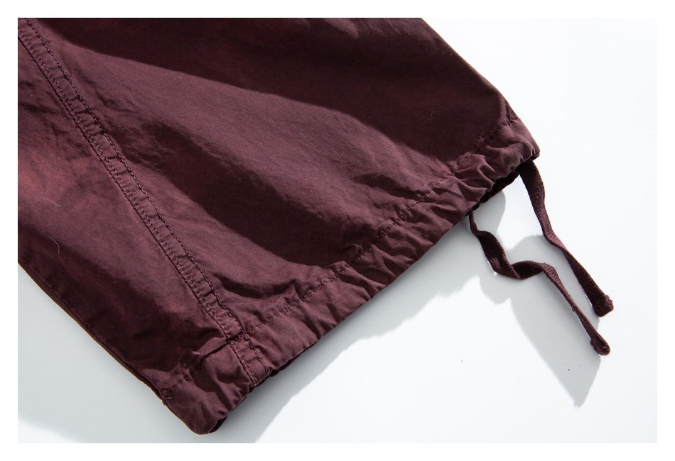 Close-up of a burgundy pants hem with an adjustable drawcord.