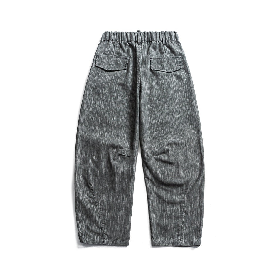Back view of gray relaxed trousers with an elastic waist and two flap pockets.