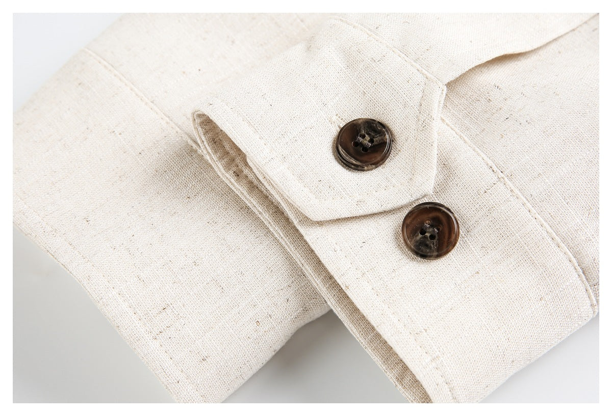 Close-up of a cream jacket sleeve cuff with two dark brown buttons.