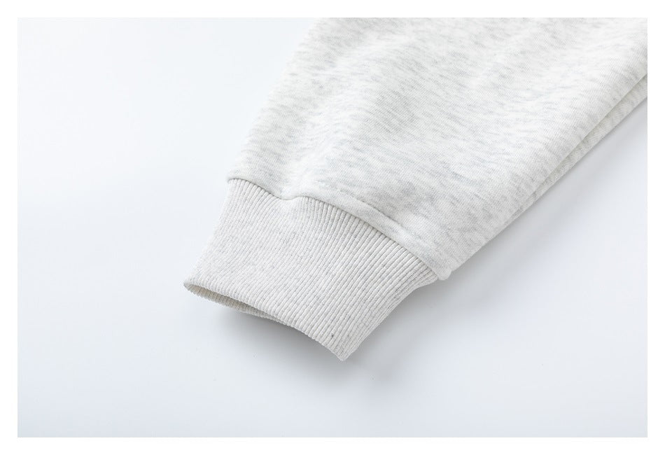 Close-up of the light gray heather sweatshirt sleeve ending in a ribbed cuff.