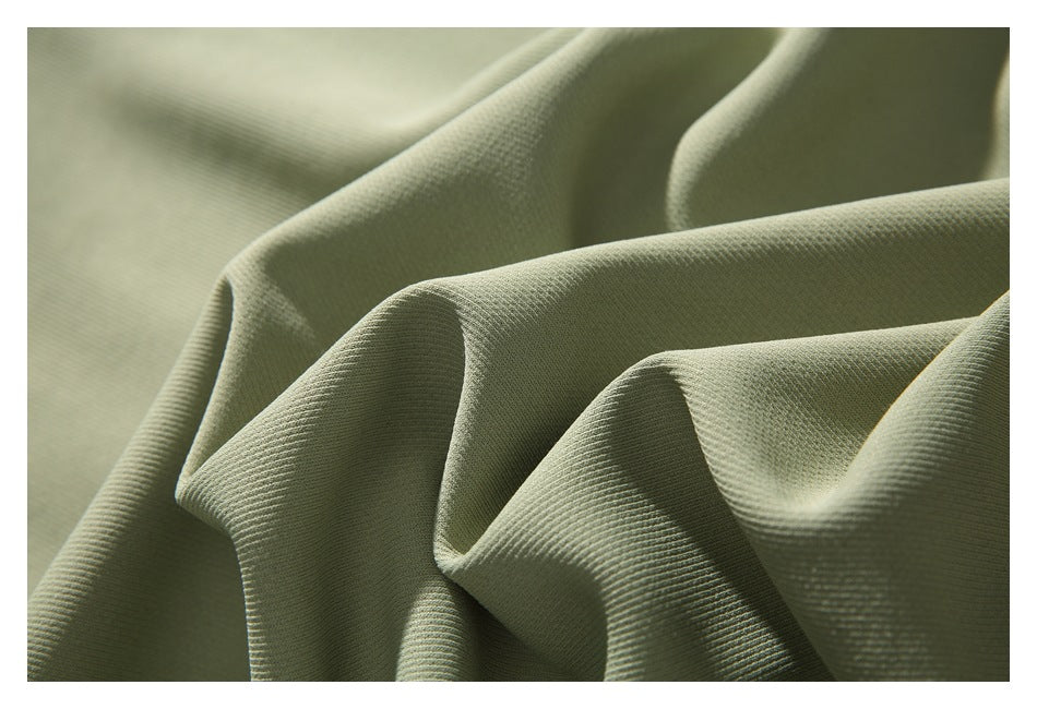 Close-up of pale sage fabric arranged in folds, showing its fine textured surface.