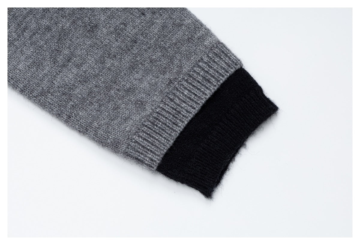 Close-up of a gray knit sleeve ending in a ribbed cuff, layered over a black knit cuff.
