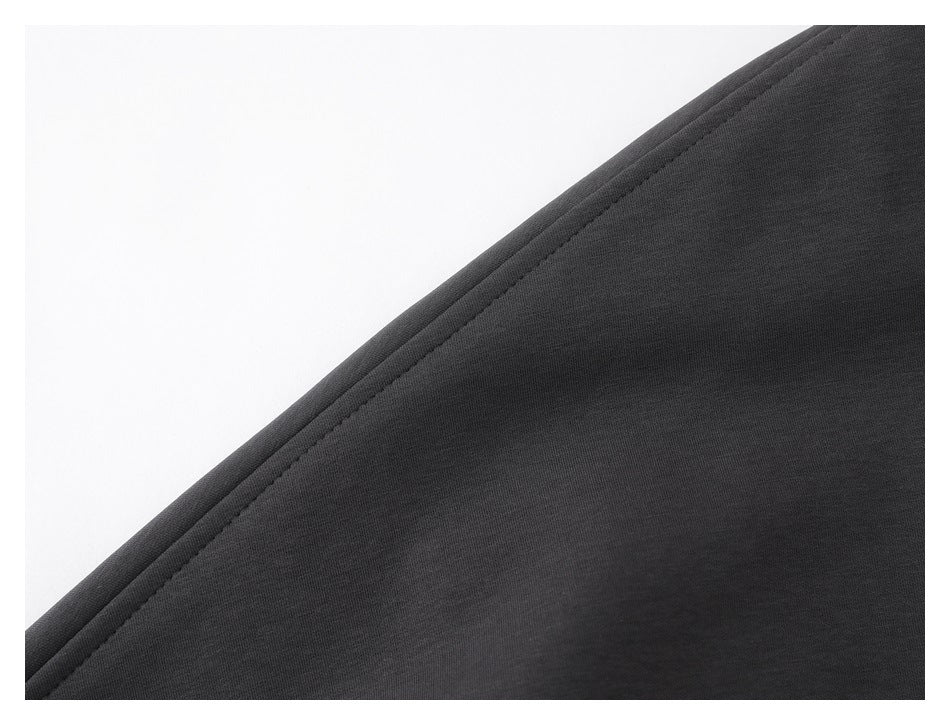 Close-up of dark charcoal fabric with a neatly stitched diagonal edge.