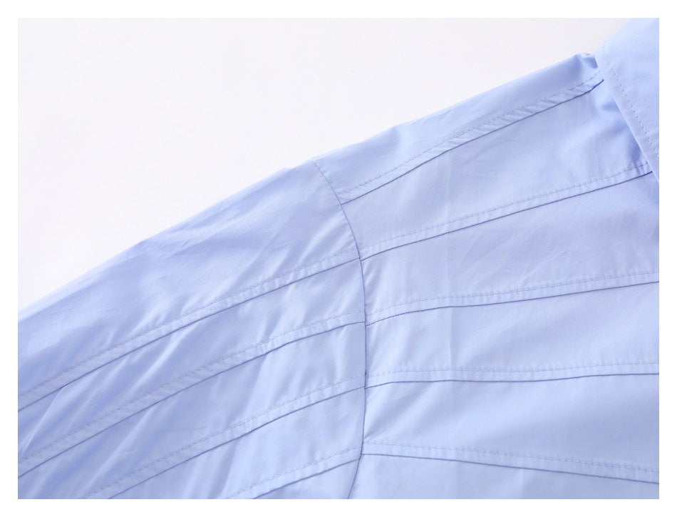 Close-up of the light blue shirt shoulder and sleeve, showing parallel stitched lines and a seam.