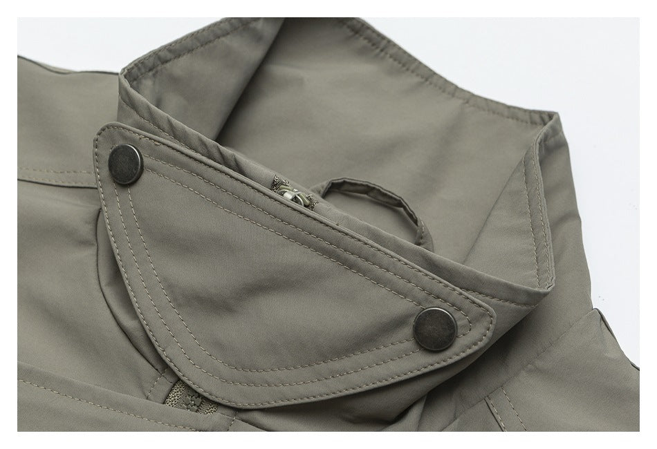 Close-up of an olive-gray garment collar with a snap-fastened flap and zipper.