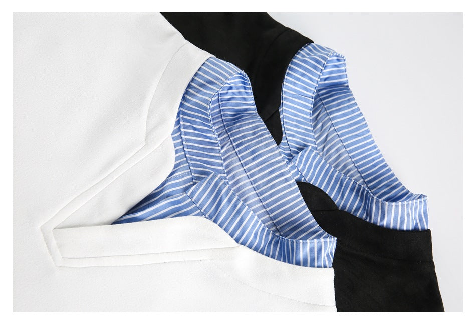Close-up of blue striped fabric layered inside the neckline of white and black tops.