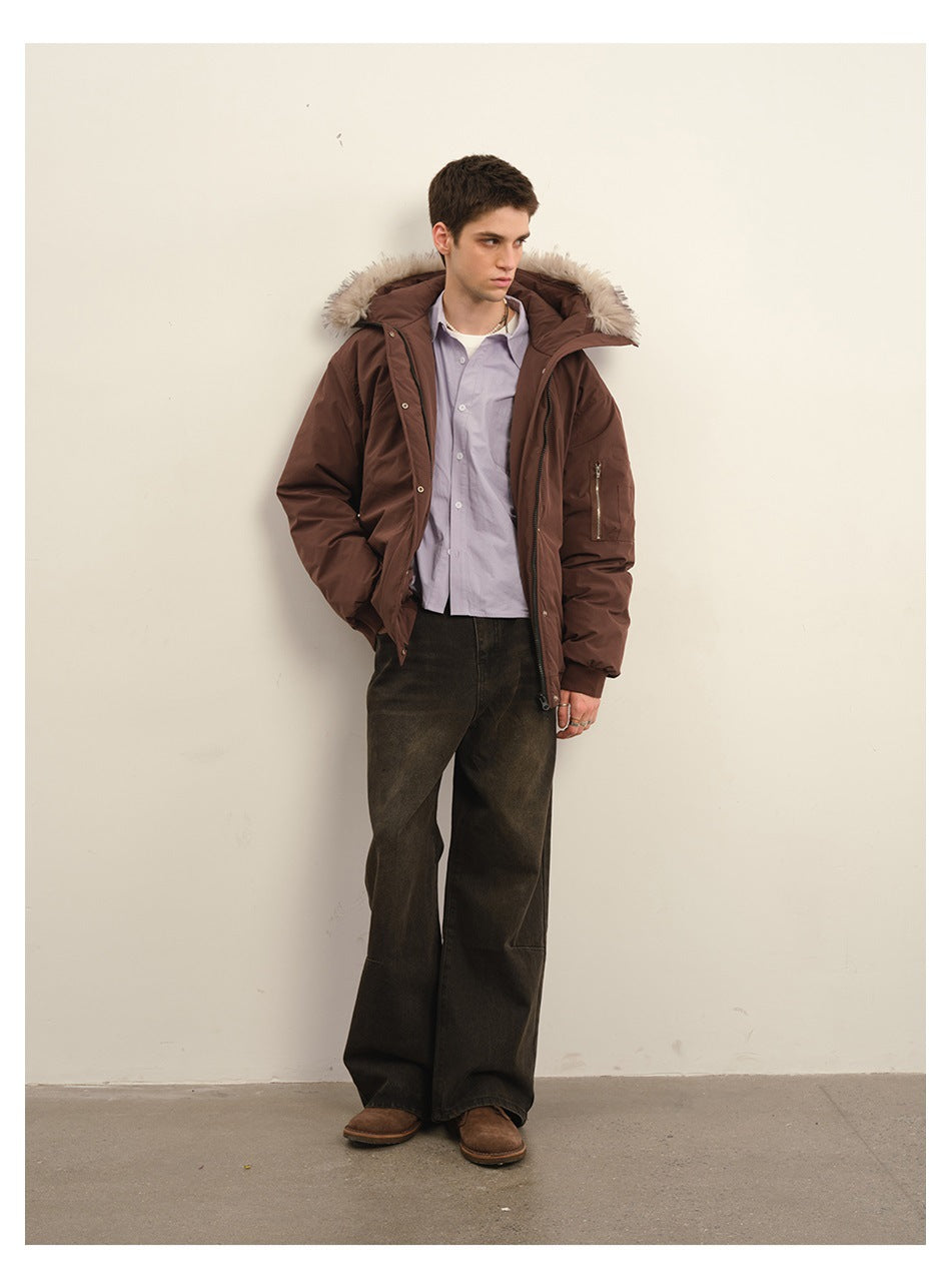 Model wearing dark red hooded jacket open over a lavender shirt with wide dark jeans and brown shoes