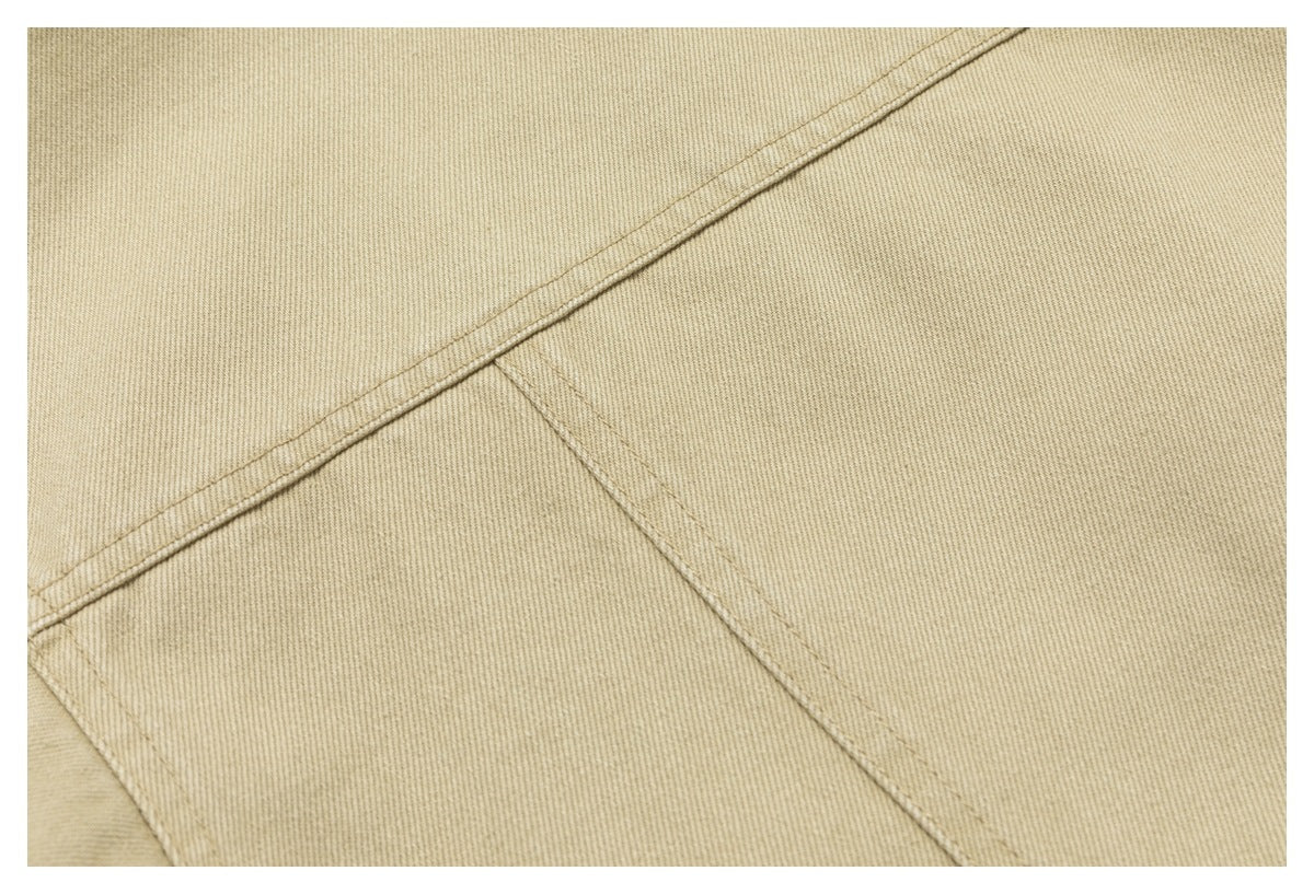 Close-up of beige garment fabric with intersecting stitched seams.