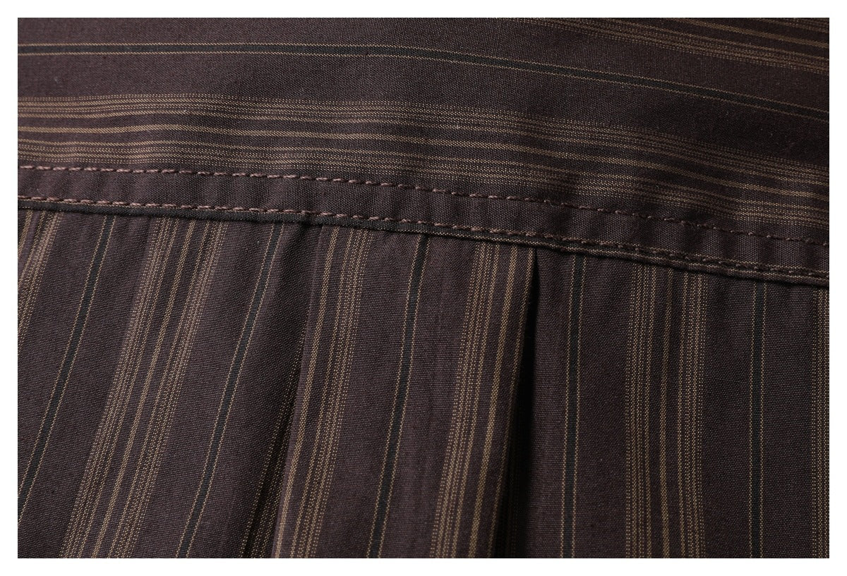 Close-up of a dark brown striped garment showing a stitched band and pleated fabric.