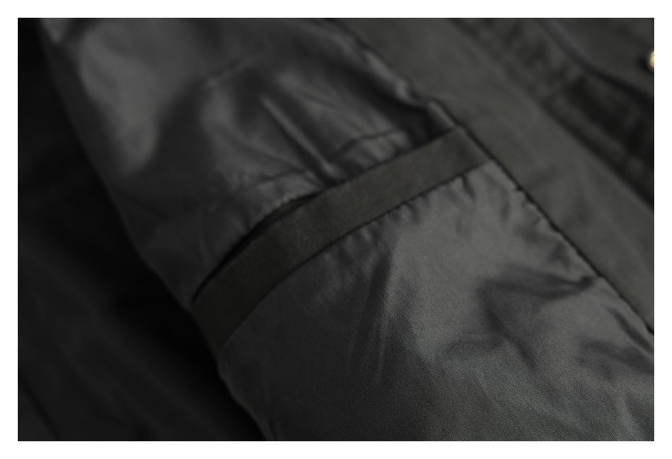 Close-up of a black sleeve with a narrow adjustable strap and stitched fabric.