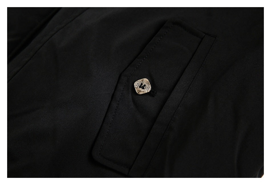 Close-up of a black jacket pocket flap with a light patterned button.