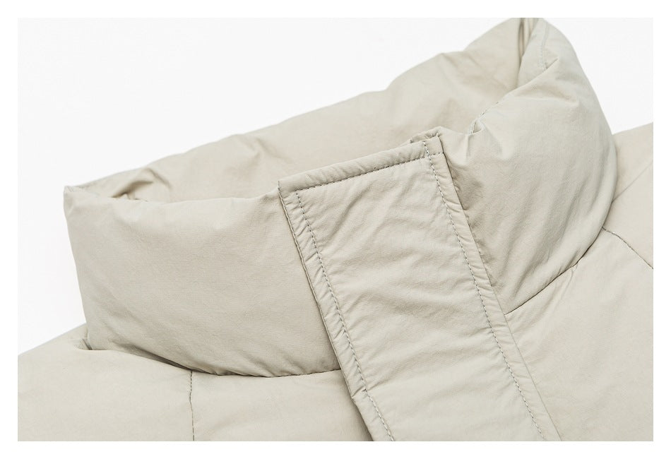 Close-up of the raised collar and stitched fabric tab on a light beige jacket.