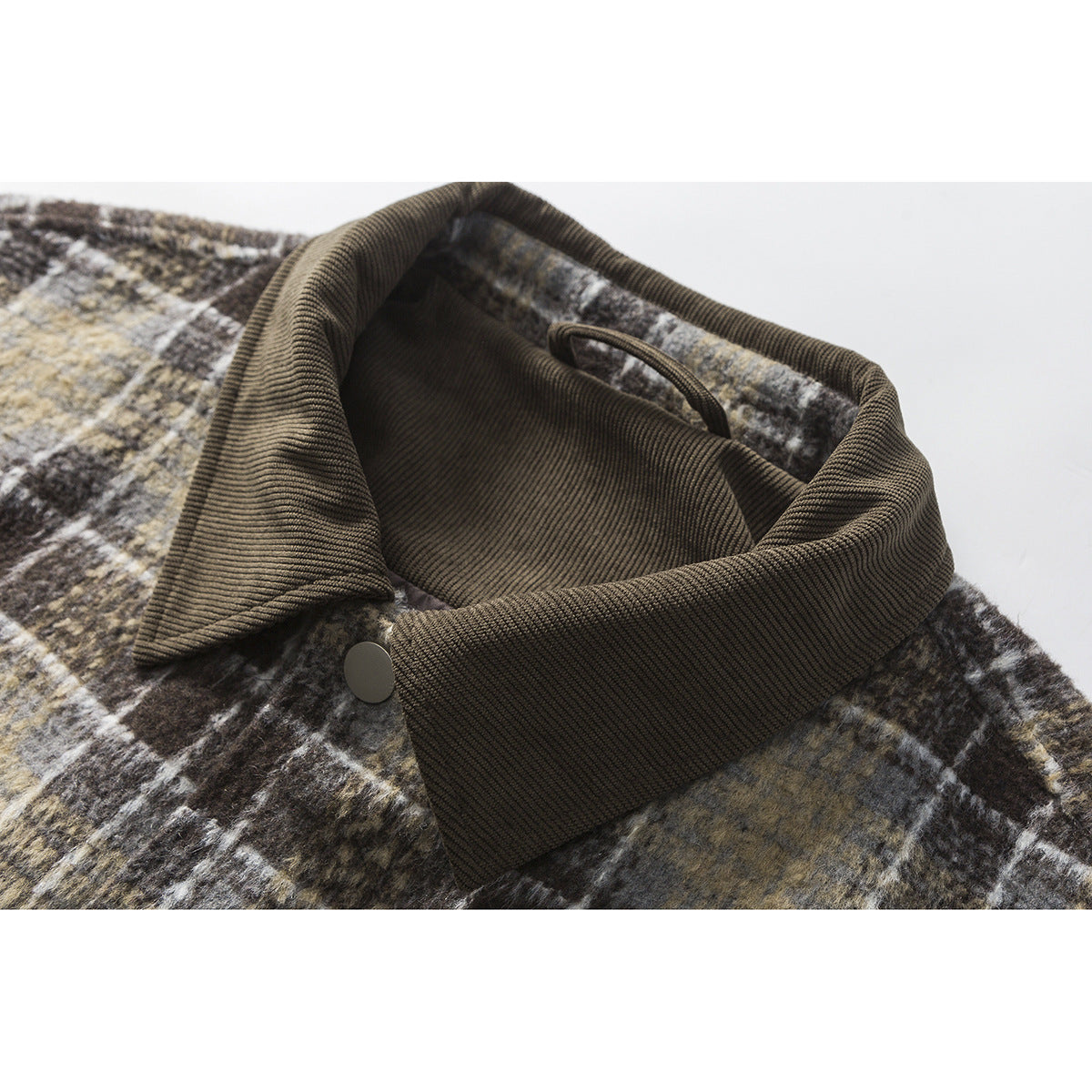 Close-up of a dark brown corduroy collar on a muted brown, gray, and cream plaid jacket.