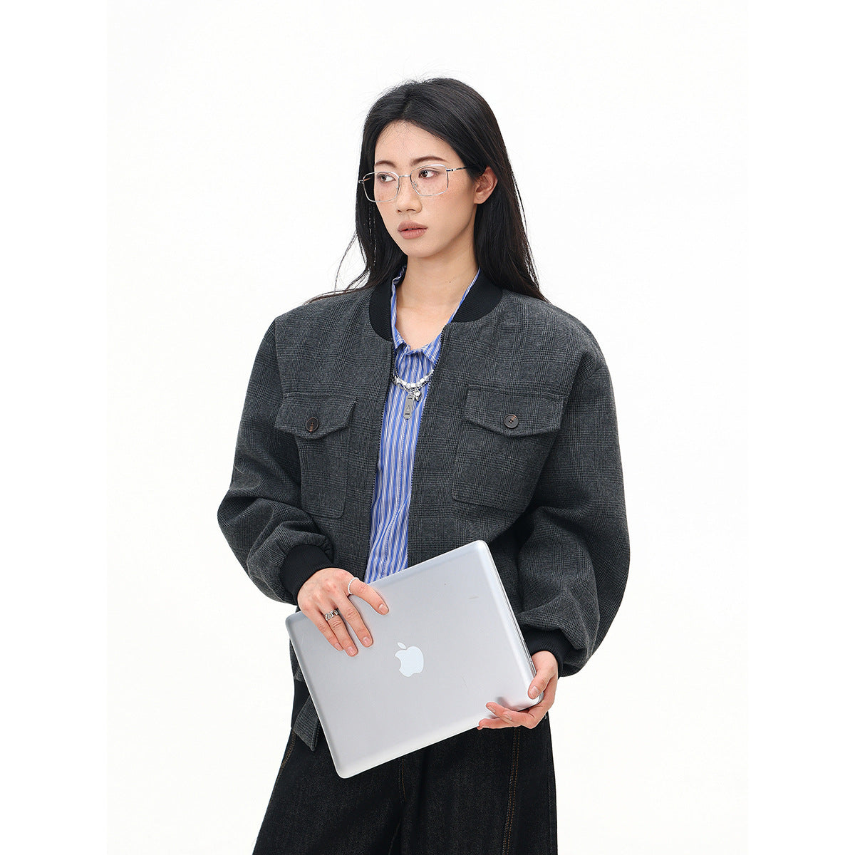 Model wearing a charcoal plaid bomber jacket with a black ribbed collar, cuffs and two button-flap chest pockets.