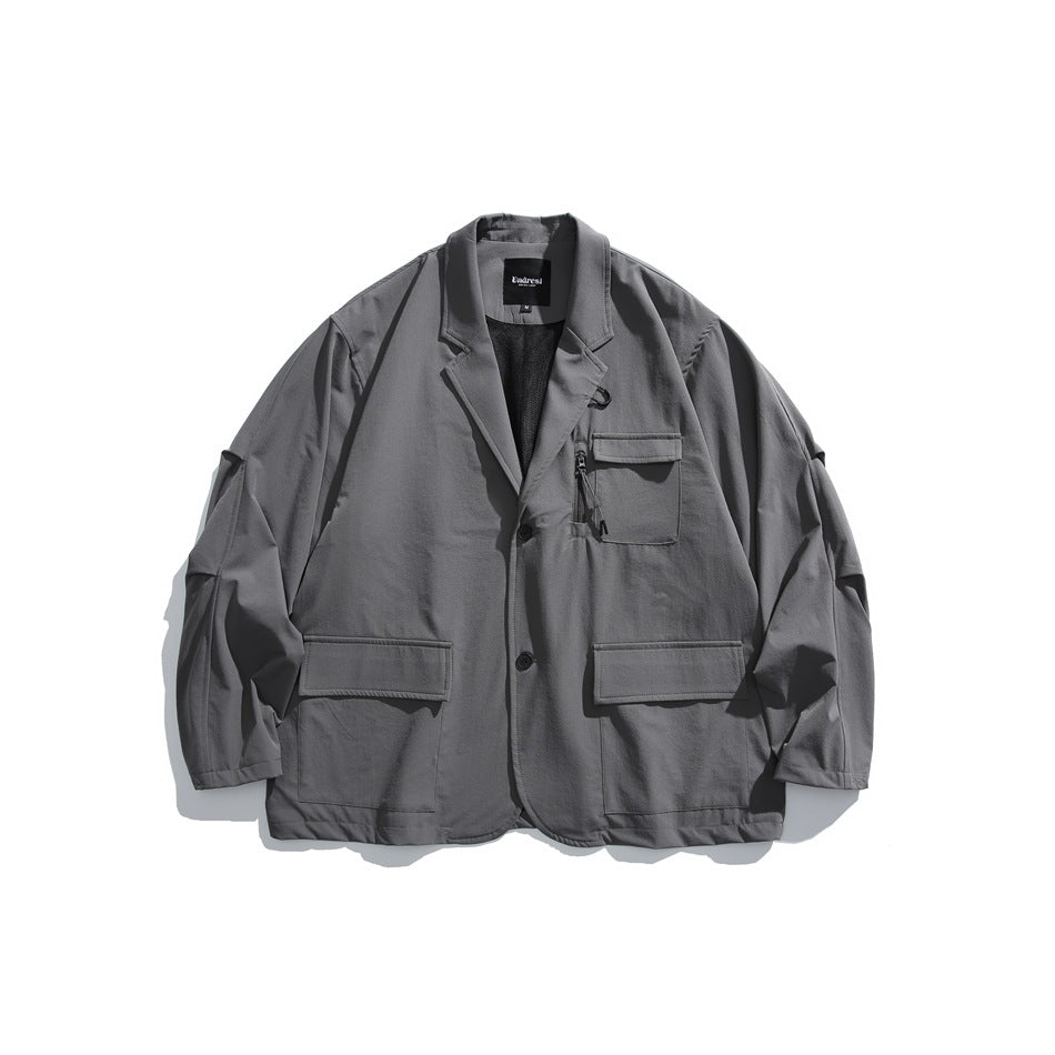 Gray blazer-style jacket flat lay with flap pockets, zip chest pocket, notch lapel and two buttons