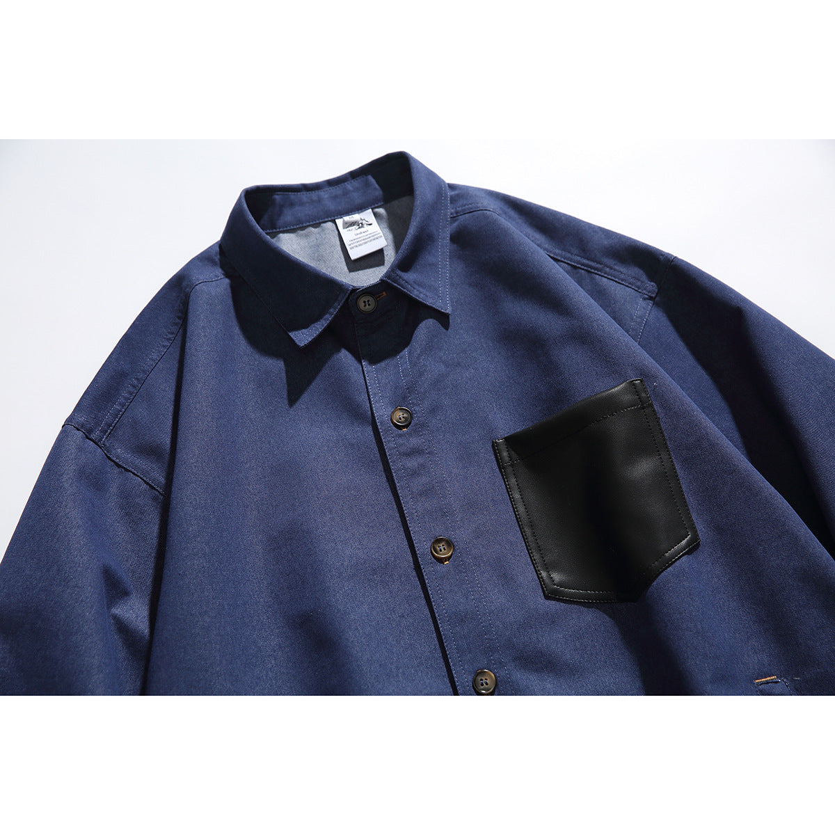 Navy button-front shirt laid flat, with a pointed collar and a large black chest pocket.