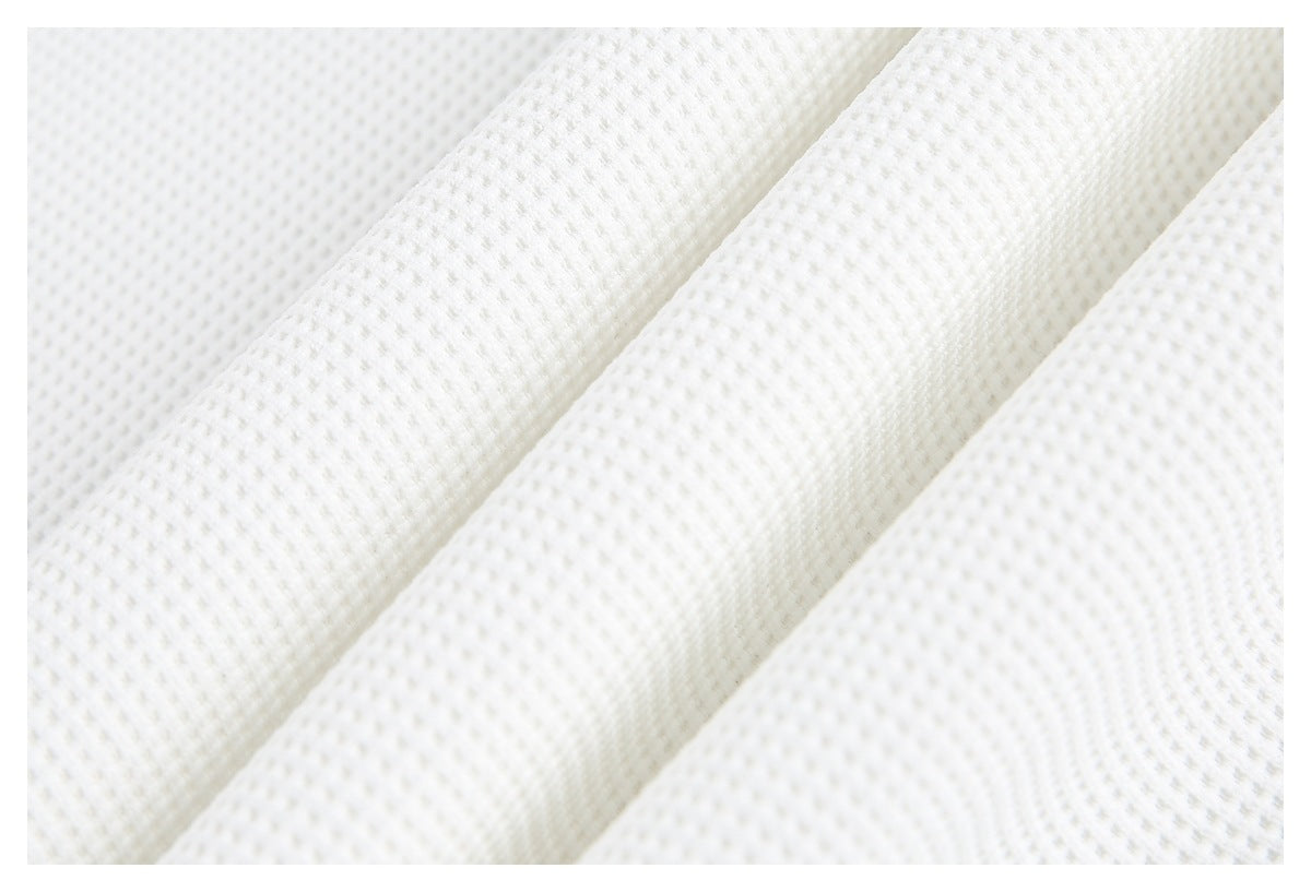 Close-up of folded ivory waffle-textured knit fabric.