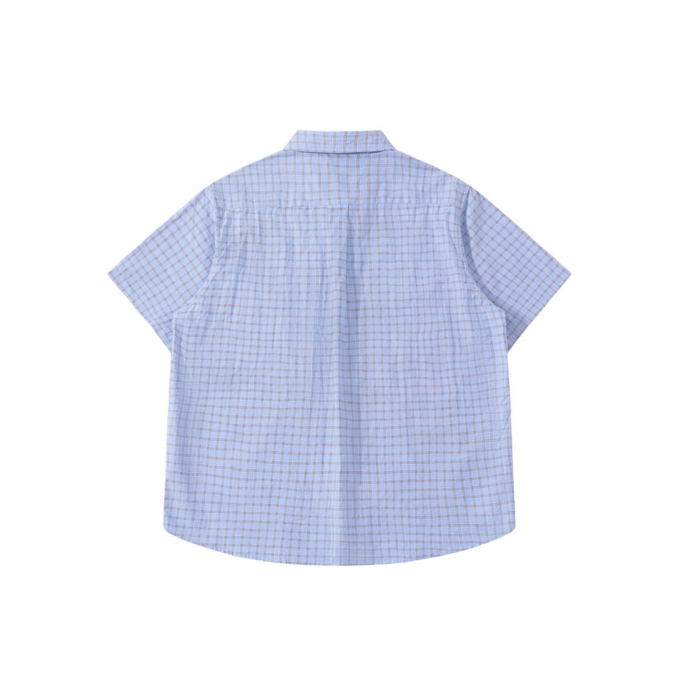 Back view of a light blue short-sleeve plaid button-up shirt laid flat against a white background.