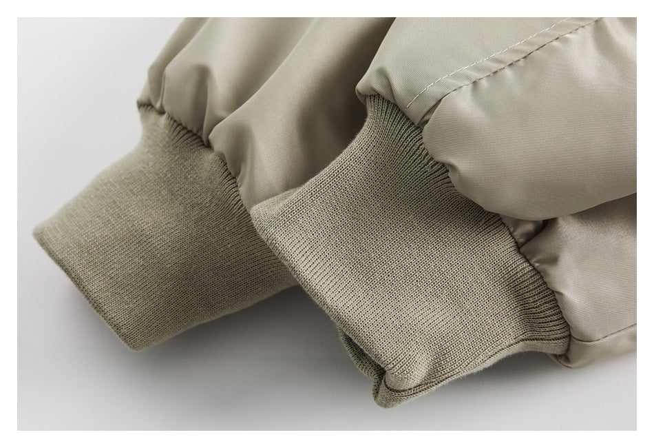 Close-up of the light khaki jacket's rib-knit cuffs and gathered sleeve fabric.