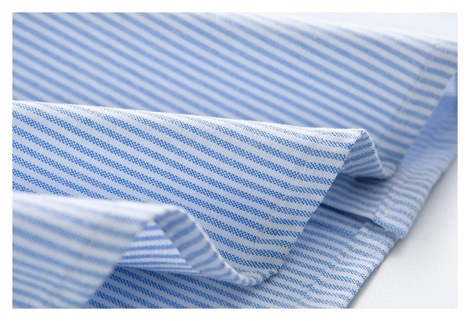 Close-up of folded white shirt fabric with narrow blue stripes.