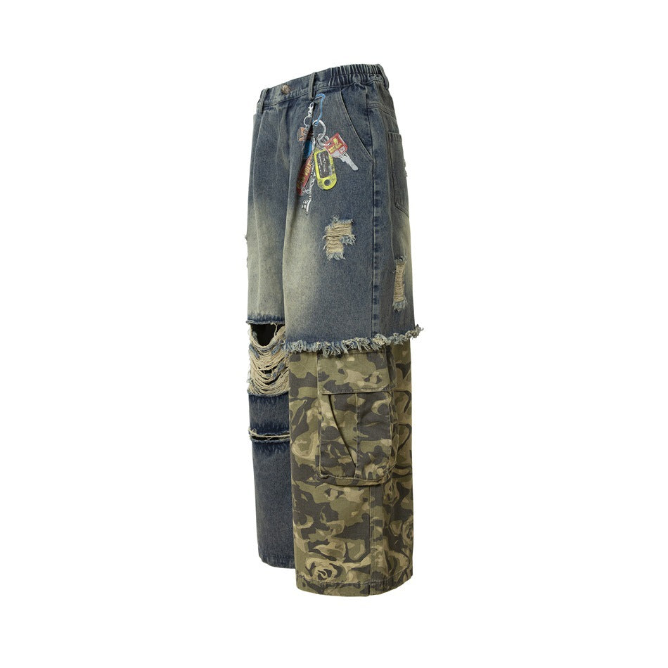 Angled side view of wide-leg distressed denim pants with a camouflage cargo panel, large pocket and dangling charms.