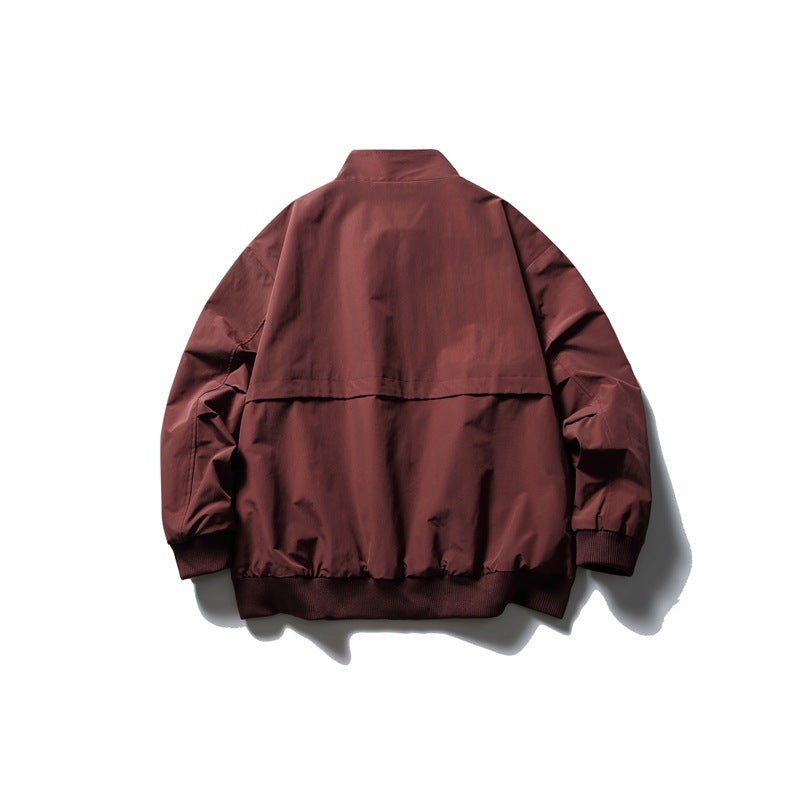 Back view of a burgundy jacket with a stand collar, shoulder yoke, gathered hem and ribbed cuffs.