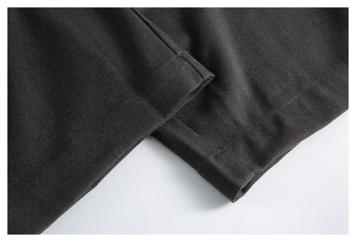 Close-up of the trousers’ folded leg hems and stitching.