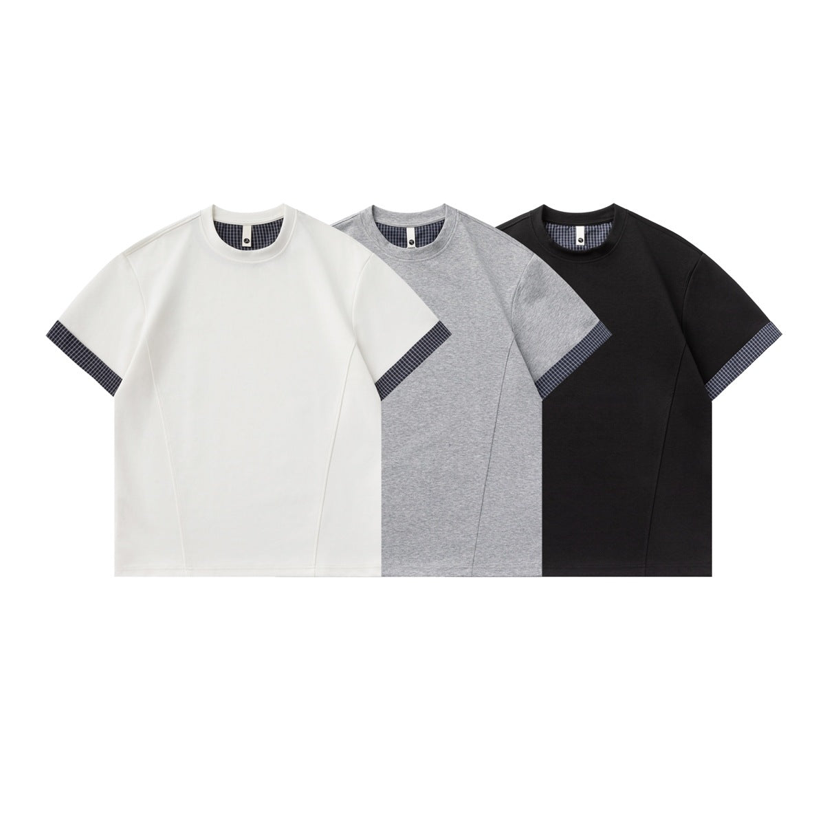 Front views of short-sleeve crew-neck T-shirts in white, heather gray, and black, each with plaid neck and cuff trim.