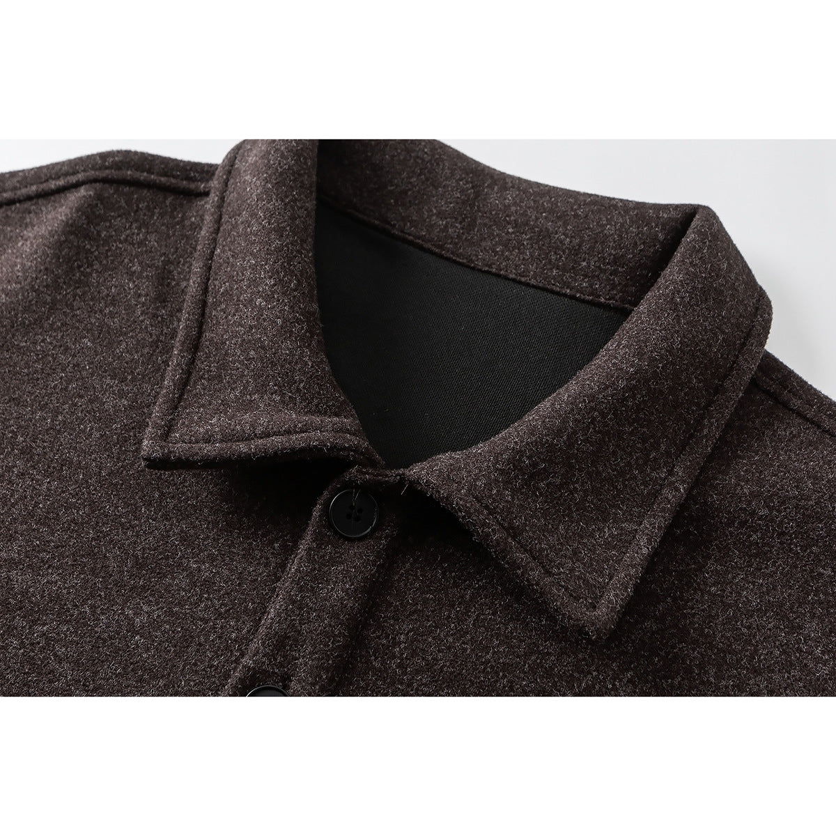 Close-up of a dark brown heathered garment's pointed collar, black buttons and front placket.