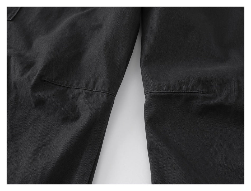 Close-up of two black pant legs showing horizontal seam details.